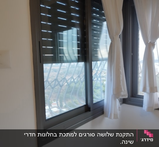 חלון עם מסגרת מתכת ווילונות לבנים